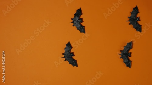 Stop motion animation halloween decor flying bats on orange background. Trick or Treat. Top view