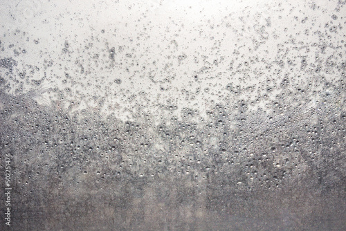 Raindrops on the surface of window panes on a cloudy day. © Maksim