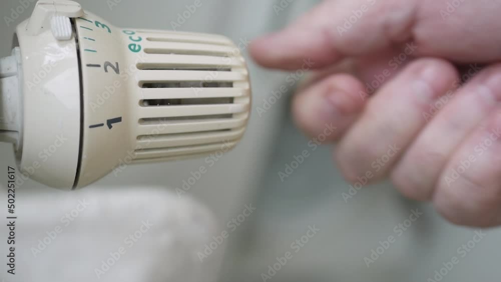 Setting Low the Radiator Temperature, Changing Thermostat Value, and Checking Thermic Energy Consumption. Energy Crisis Concept. Setting Low the Radiator Temperature, Changing Thermostat Value, and Checking Thermic Energy Consumption. Energy Crisis Concept.