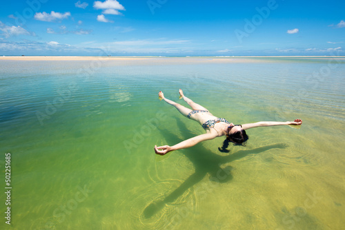 A woman floats in a pool of seawater by the sunny beach on Moreton Island photo