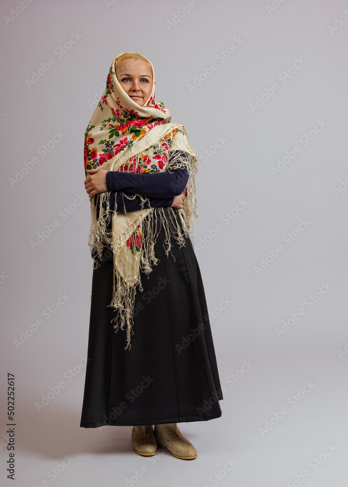 woman covered her head with a colored Russian scarf on a white background