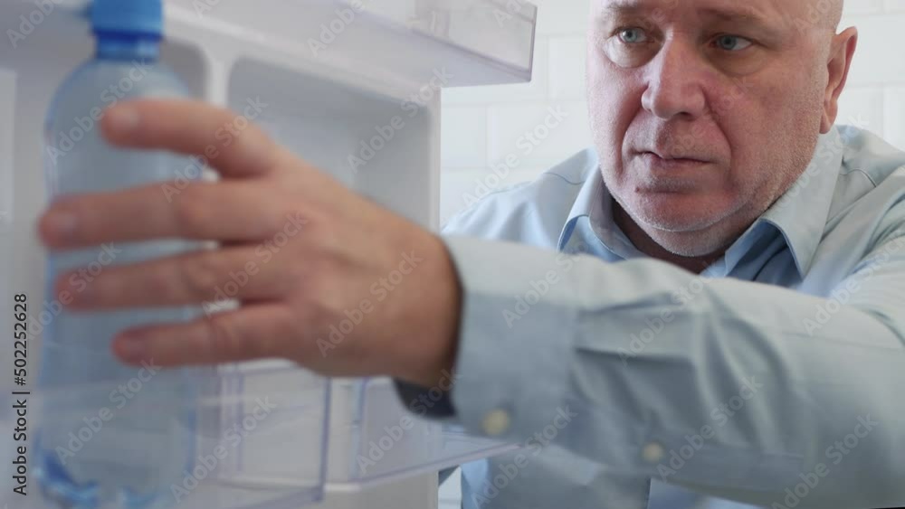 Thirsty Person Opens the Fridge Door and Take a Bottle with Fresh and Chill Natural Water. Food Crisis, Empty Fridge Concept. Thirsty Person Opens the Fridge Door and Take a Bottle with Fresh and Chill Natural Water. Food Crisis, Empty Fridge Concept.