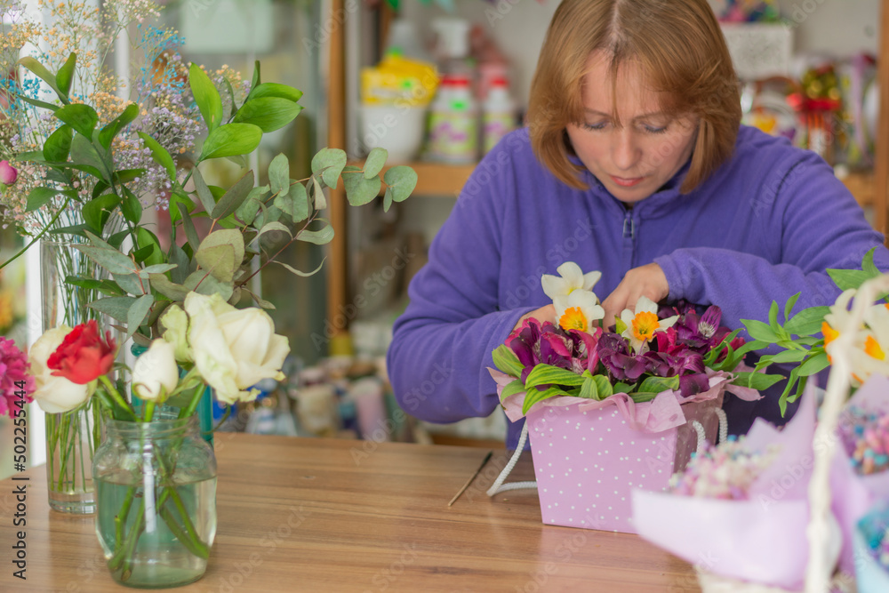 Workplace of a florist table in a flower shop florist creates a bouquet of flowers in a box Workplace of a florist table in a flower shop florist creates a bouquet of flowers in a box