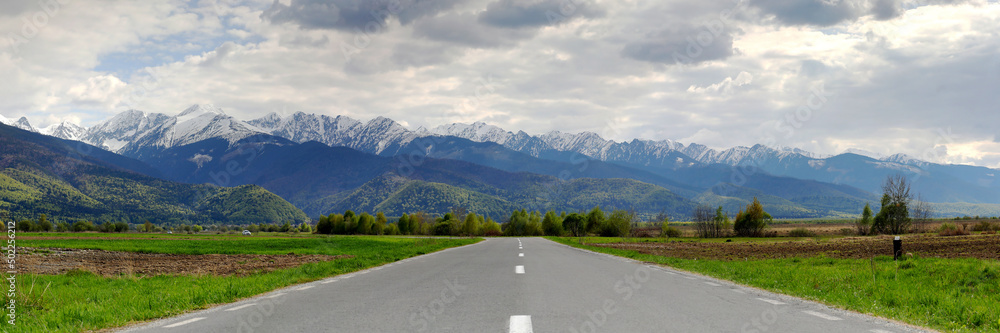 Fototapeta premium Panoramic view of the famous Romanian mountains Fagaras with snow-capped peaks on a cloudy day.