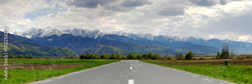 Panoramic view of the famous Romanian mountains Fagaras with snow-capped peaks on a cloudy day.