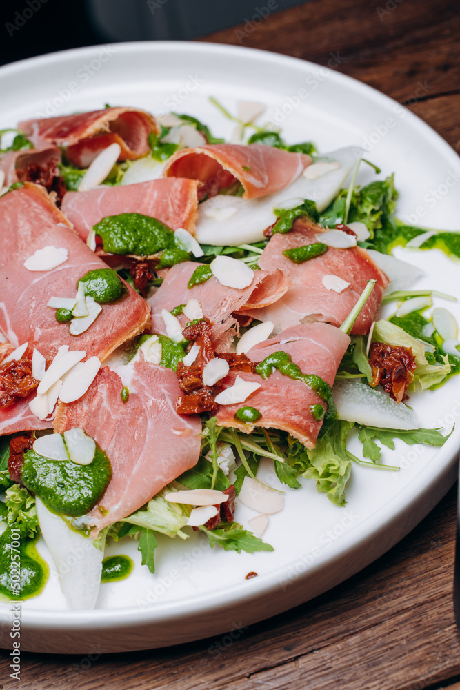salad with prosciutto and avocado with avocado sauce on a white plate salad with prosciutto and avocado with avocado sauce on a white plate