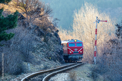 red passenger train in the mountains