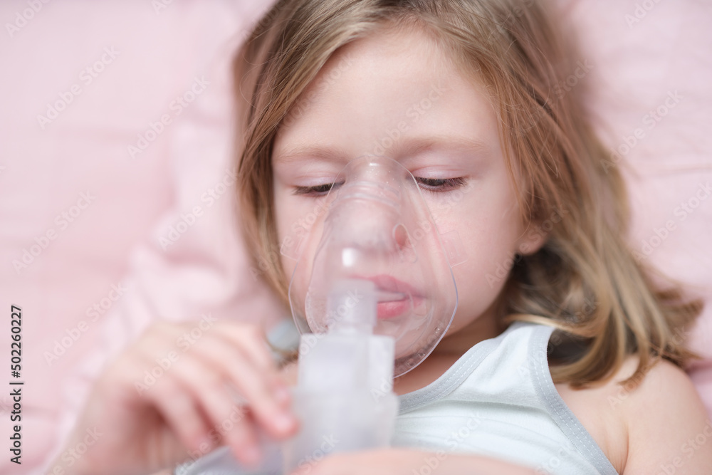 Little sad girl having inhalation for easing cough Little sad girl having inhalation for easing cough