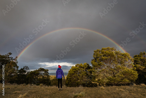 figure in nature looking towards a rainbow