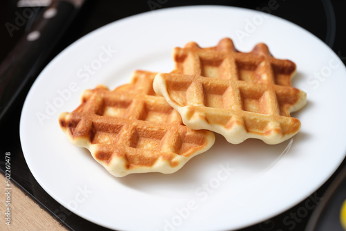 Delicious belgian waffles on white plate, yummy breakfast