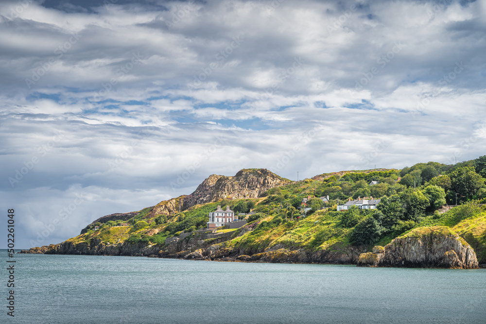 Obraz premium Beautiful Howth cliff walk with some residential houses and lush green vegetation, Dublin, Ireland