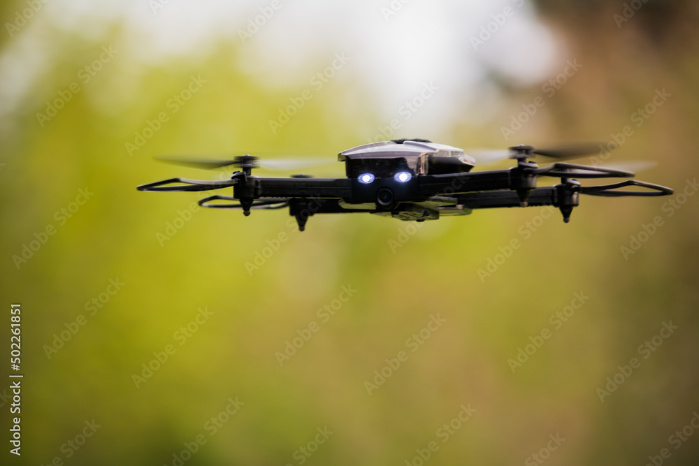 Drone in flight at eye-level with blurred background (Unmanned Aircraft System, Unmanned Aerial Vehicle, Unmanned Aerial System, UAV, UAS) Drone in flight at eye-level with blurred background (Unmanned Aircraft System, Unmanned Aerial Vehicle, Unmanned Aerial System, UAV, UAS)