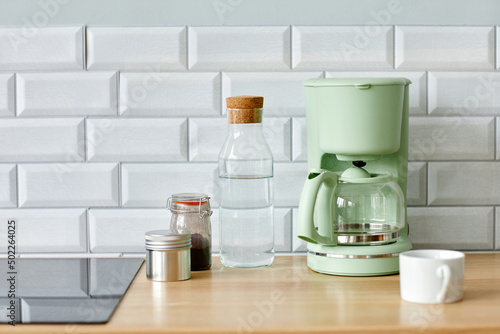 Minimal background image of home coffee station on wooden kitchen counter in morning, copy space