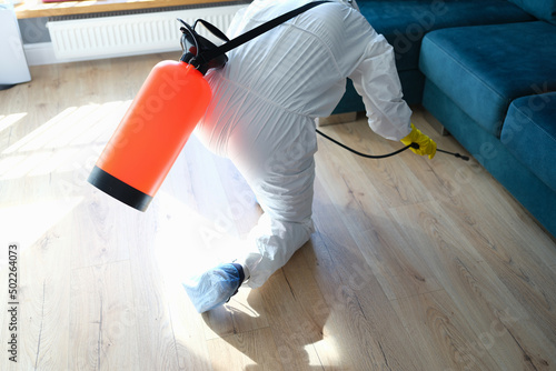 Man in hazmats making disinfection in flat