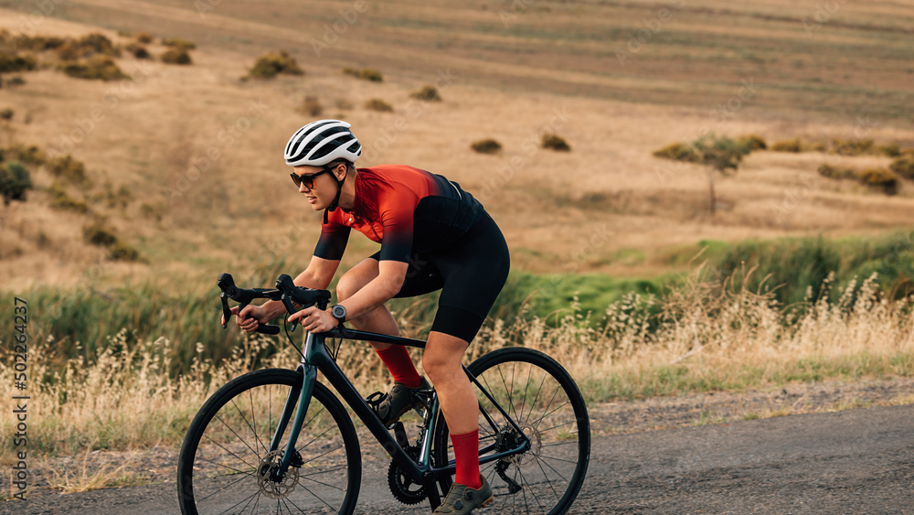 Road bike cyclist riding on pro bike outdoors on countryside road