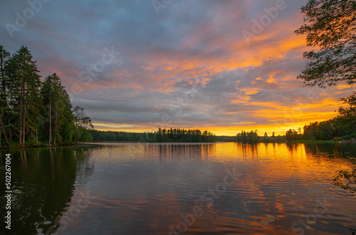 Beautiful red sunset on a forest lake.Rest on the lake in the forest. Evening fishing. Crimson sunset on the water.