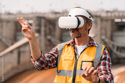 Senior engineer wearing AR goggle and browsing work area thought the virtual reallity. Technology Virtual reallity for industrial work space.