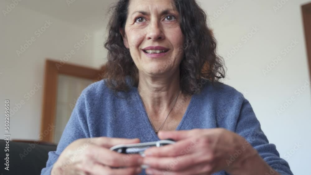 Slow motion shot of senior woman enjoying video games Slow motion shot of senior woman enjoying video games