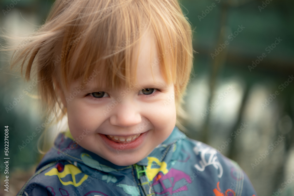 Child smiles face portrait on blurry background, shallow focus Child smiles face portrait on blurry background, shallow focus