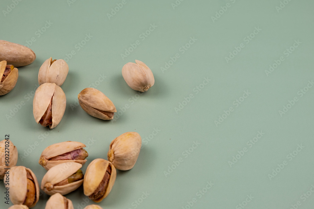 Organic Pistachio Shells on a green table, with copy space.