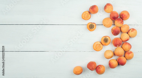 Ripe apricots and apricot leaves in a bowl on a wooden table. Fresh fruits from the home garden. Healthy food. Flat lay