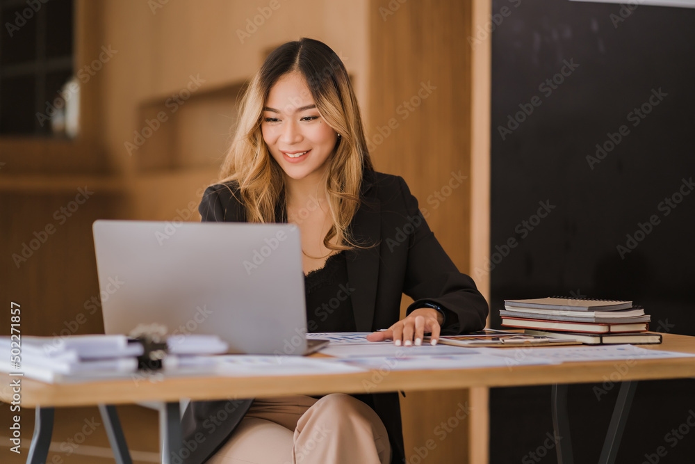 Asian businesswoman in formal suit in office happy and cheerful during using smartphone and working Asian businesswoman in formal suit in office happy and cheerful during using smartphone and working
