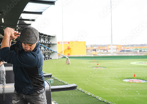 Man playing golf in modern golf location