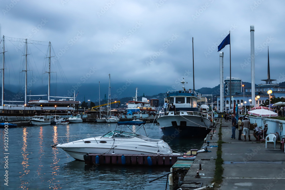 A parked boat at the pier in the morning against the background of other ships