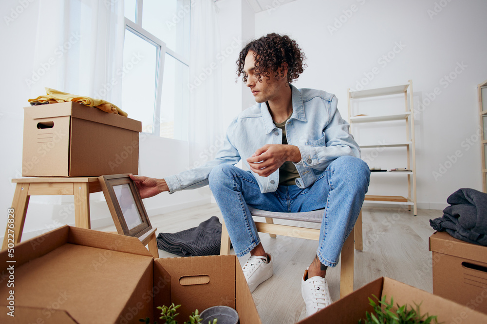portrait of a man unpacking things from boxes in the room Lifestyle portrait of a man unpacking things from boxes in the room Lifestyle