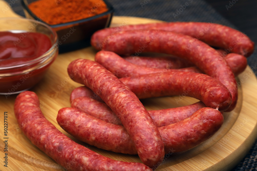 hunting sausages on a serving board with ground pepper and tomato sauce. Shallow depth of field hunting sausages on a serving board with ground pepper and tomato sauce. Shallow depth of field