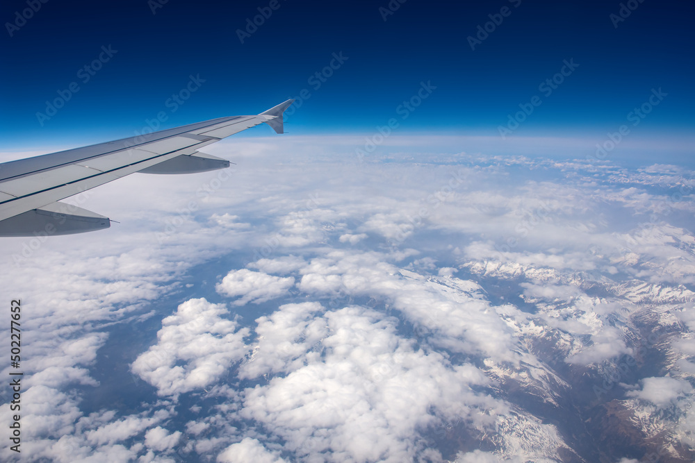 View from an airplane window on clouds and blue sky View from an airplane window on clouds and blue sky