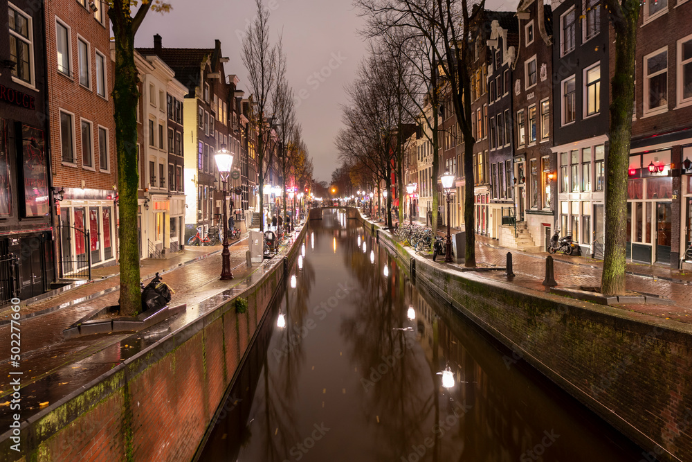 AMSTERDAM, NETHERLANDS - DECEMBER 12, 2021. Dutch houses  at night Christmas time in the old city.