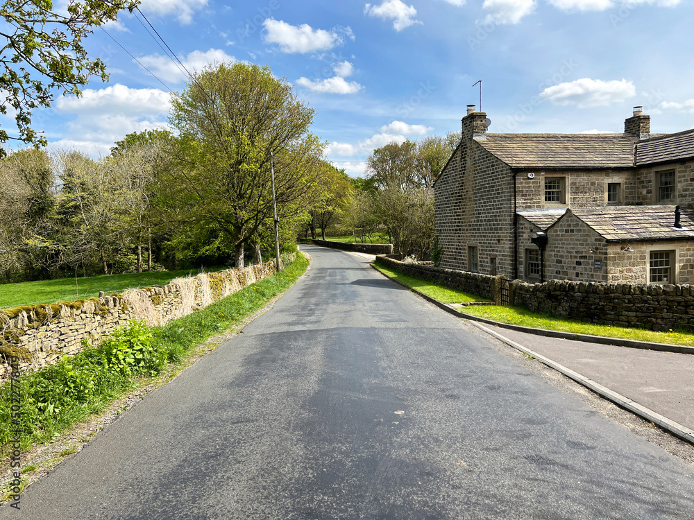 Looking along, Carr Head Lane, with dry stone walls, cottages, farms, and old trees in, Cowling, Keighley, UK