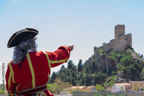 An unrecognizable person pointing to the castle of Almansa, Spain photo