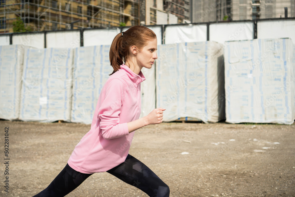 Young woman doing a leg stretching exercise Young woman doing a leg stretching exercise