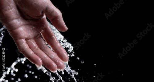 hand with water splash on black background,Wash your hands