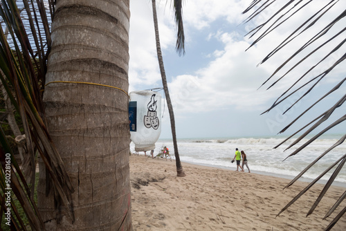 PALOMINO, COLOMBIA - Rustic Ashtray hangin to a palm beach near to beach photo