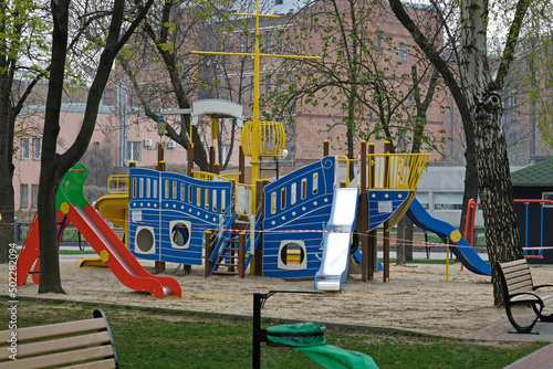 Empty playground in the city park. Playground in the shape of a ship, with slides and stairs. Bright playground for children in the city center.