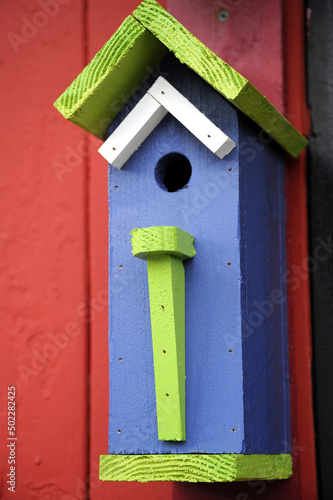 Colorful bird house feeder displayed outdoors.