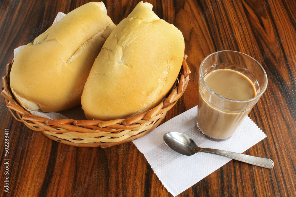 Bread basket with latte glass on rustic table. Bread basket with latte glass on rustic table.