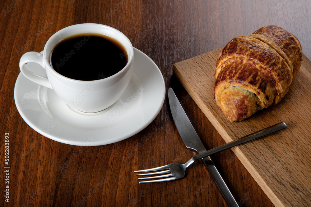 Croissant with a cup of full coffee,directly above Croissant with a cup of full coffee,directly above