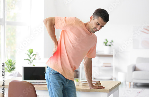Young man feeling back pain...
