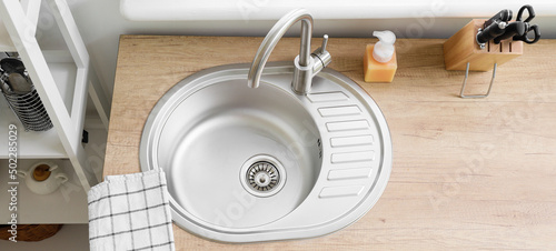 Tableau sur toile Wooden counter with metal sink in kitchen, top view