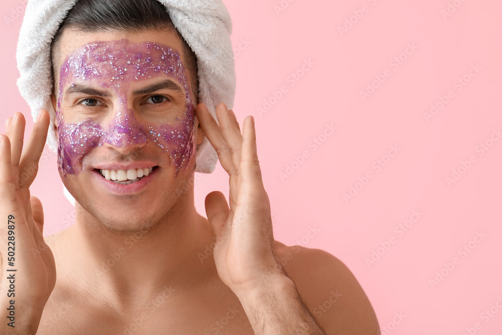 Handsome man with glitter mask and towel on pink background Handsome man with glitter mask and towel on pink background