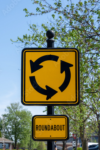 yellow and black roundabout traffic sign