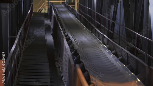 Machines working and conveyor line transporting sand. Stock footage. Conveyor belt with small pebble at the concrete mixing plant  factory equipment.