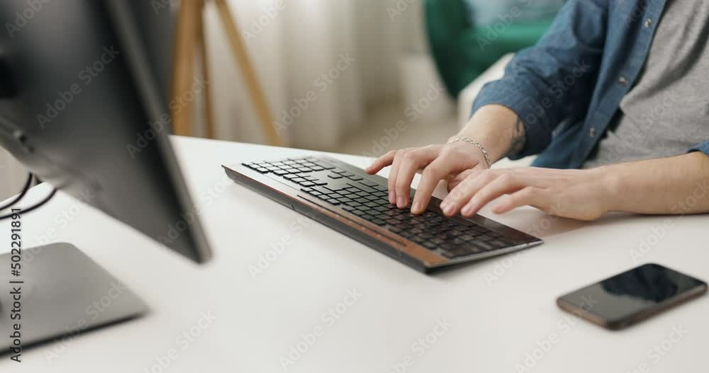 Close up of male hands typing on keyboard of modern pc. Caucasian man sitting at desk and using stationary computer for coding at home.