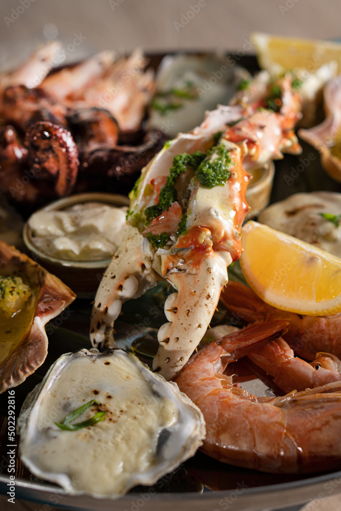 Baked oysters, crab with sauce and a slice of lemon. A glass of white wine with a seafood platter Baked oysters, crab with sauce and a slice of lemon. A glass of white wine with a seafood platter