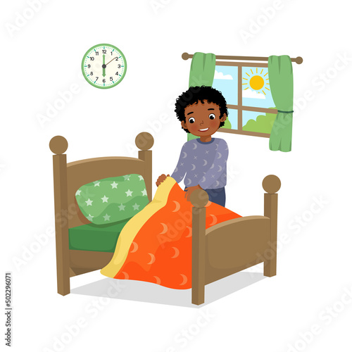 cute little African boy making bed arranging pillow and bed cover neat doing her housework chores in the morning at home