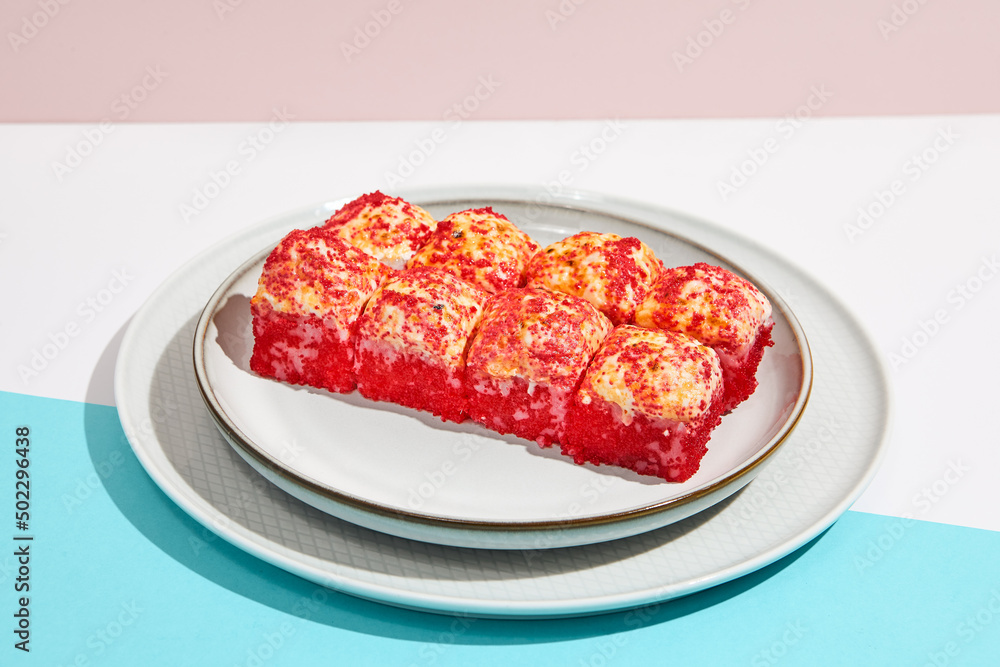 Baked Maki roll with tobiko caviar on ceramic plate. Hot sushi roll with tobiko and cheese topped on coloured background. Japanese menu concept. Hot maki sushi in modern style. Baked Maki roll with tobiko caviar on ceramic plate. Hot sushi roll with tobiko and cheese topped on coloured background. Japanese menu concept. Hot maki sushi in modern style.